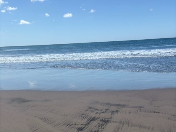 Smuk sandstrand med bølger ved Stillehavet i Nicaragua